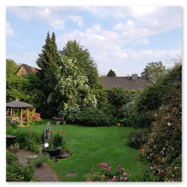 Blick auf die Rasenfläche und den Schieferpavillon